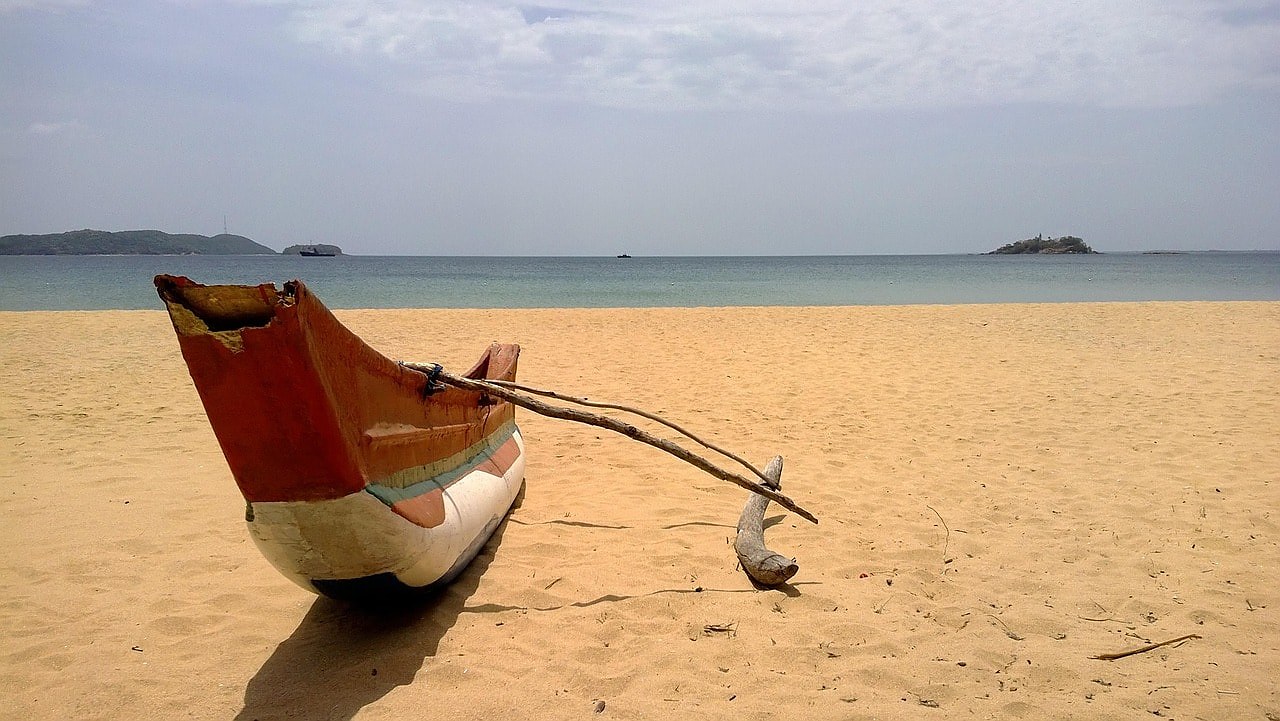 Shoulder season Sri Lanka — quiet beach with traditional fishing boat